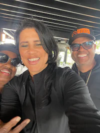 three people are smiling while taking a selfie